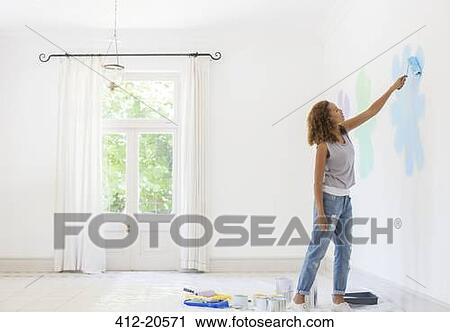 Woman painting wall in living space View Large Photo Image Stock Image - Woman painting wall in living space. Fotosearch