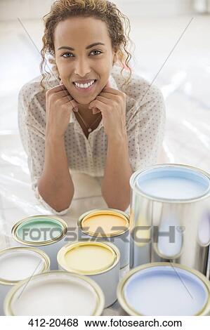 Stock Photo - Woman sitting in front of paint cans . Fotosearch