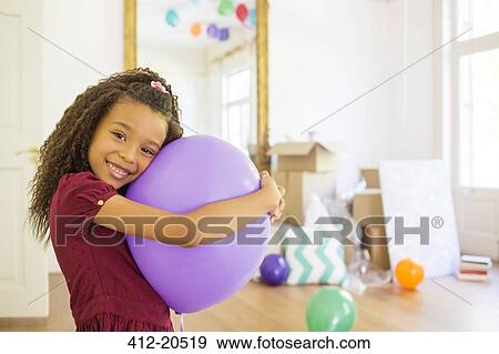 Young girl hugging purple balloon View Large Photo Image Stock Photo - Young girl hugging purple balloon. Fotosearch