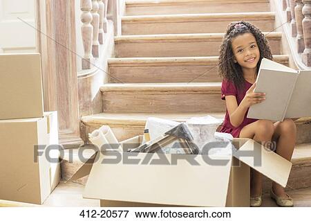 Young girl reading while sitting on stairs View Large Photo Image Stock Photo - Young girl reading while sitting on stairs. Fotosearch