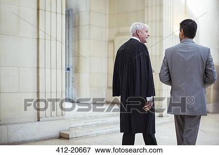 Judge and lawyer walking through courthouse together View Large Photo Image Stock Photo - Judge and lawyer walking through courthouse together . Fotosearch