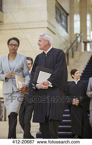 Stock Photo - Judge and lawyer walking together through courthouse. Fotosearch