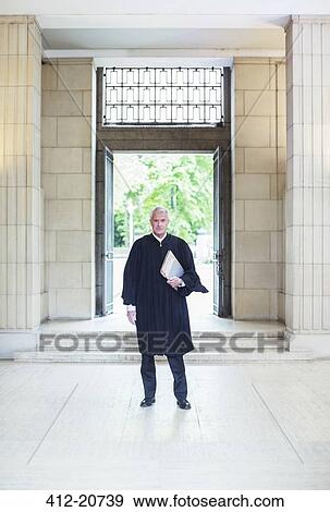 Stock Photo - Judge standing in front of doors to courthouse . Fotosearch