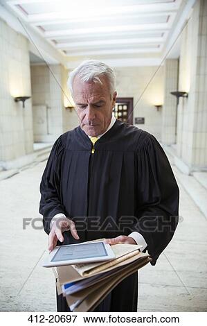 Stock Photo - Judge using digital tablet in courthouse. Fotosearch