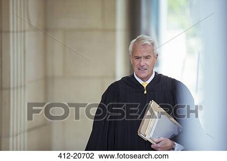 Stock Image - Judge walking through courthouse. Fotosearch