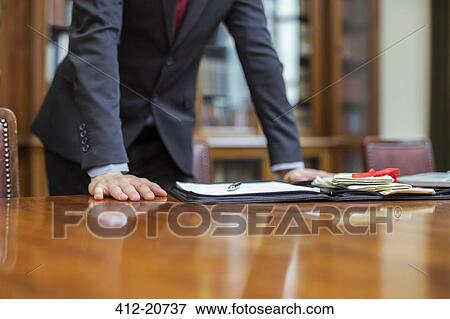 Lawyer leaning on table in chambers View Large Photo Image Stock Photo - Lawyer leaning on table in chambers . Fotosearch
