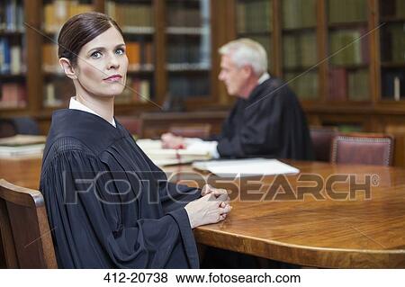 Lawyer sitting at meeting table in chambers View Large Photo Image Stock Photo - Lawyer sitting at meeting table in chambers. Fotosearch