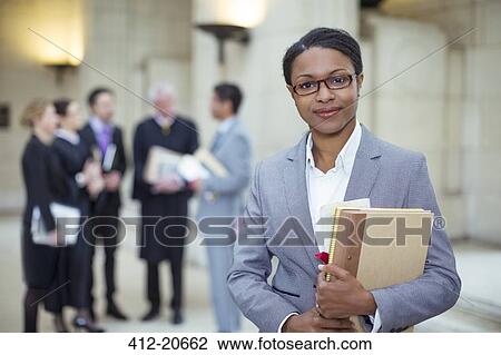 Lawyer standing with documents in courthouse View Large Photo Image Stock Image - Lawyer standing with documents in courthouse. Fotosearch