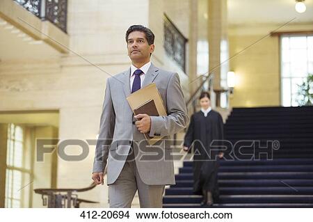 Lawyer walking through courthouse View Large Photo Image Picture - Lawyer walking through courthouse. Fotosearch