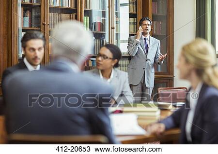 Stock Image - Lawyers talking on cell phone in chambers. Fotosearch