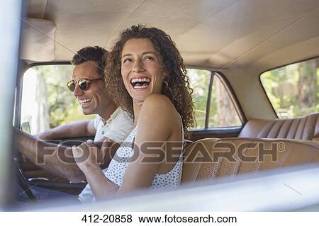Couple laughing during car ride View Large Photo Image Stock Photo - Couple laughing during car ride. Fotosearch