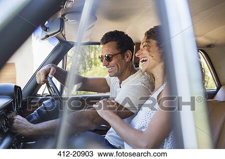 Couple riding in car on sunny day View Large Photo Image Stock Image - Couple riding in car on sunny day. Fotosearch