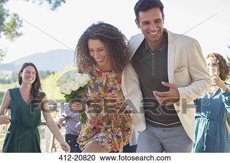 Couple running together at family picnic View Large Photo Image Stock Image - Couple running together at family picnic . Fotosearch