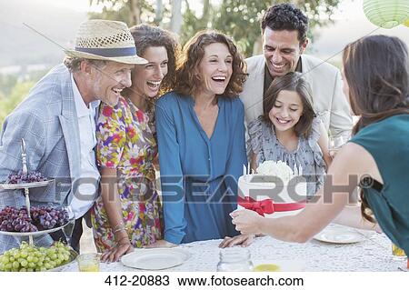 Stock Image - Family celebrating birthday with cake . Fotosearch