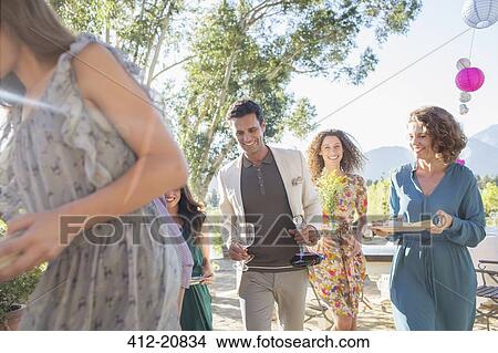 Picture - Family moving dishes from table outdoors. Fotosearch