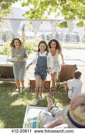 Stock Image - Family running through park together . Fotosearch