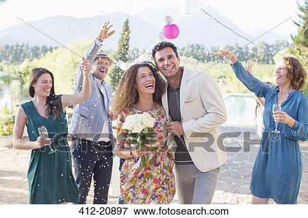 Stock Photo - Family throwing rice on newlywed couple. Fotosearch