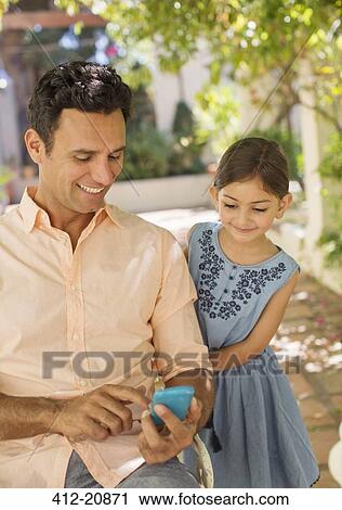 Father and daughter looking at cell phone View Large Photo Image Stock Image - Father and daughter looking at cell phone . Fotosearch