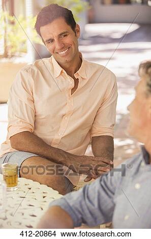 Father and son sat at table enjoying the outdoors View Large Photo Image Picture - Father and son sat at table enjoying the outdoors. Fotosearch