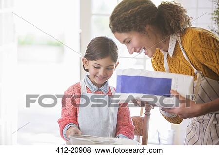 Mother and daughter baking together View Large Photo Image Stock Photo - Mother and daughter baking together. Fotosearch