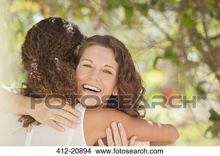 Mother and daughter hugging outdoors View Large Photo Image Picture - Mother and daughter hugging outdoors. Fotosearch