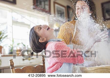 Mother and daughter playing with flour in the kitchen View Large Photo Image Stock Photography - Mother and daughter playing with flour in the kitchen . Fotosearch