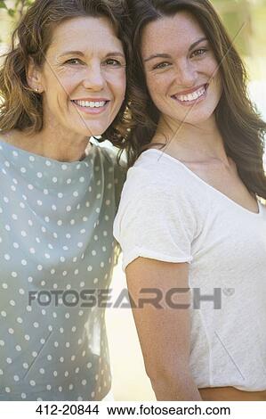 Picture - Mother and daughter smiling together outdoors. Fotosearch