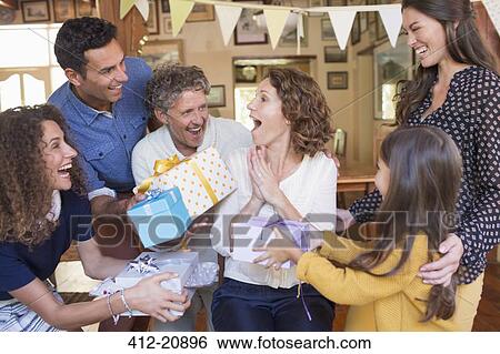 Older woman being given gift by family View Large Photo Image Stock Photograph - Older woman being given gift by family. Fotosearch