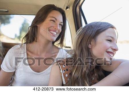 Stock Image - Sisters riding in car backseat together. Fotosearch