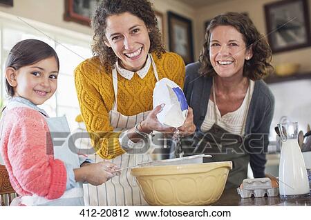 Stock Image - Three generations of women baking together. Fotosearch