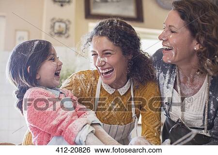 Stock Photograph - Three generations of women playing in the kitchen. Fotosearch