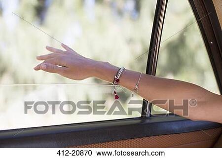 Woman feeling wind on her hand through car window View Large Photo Image Stock Image - Woman feeling wind on her hand through car window . Fotosearch