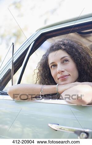 Woman relaxing on car door during car ride View Large Photo Image Picture - Woman relaxing on car door during car ride. Fotosearch