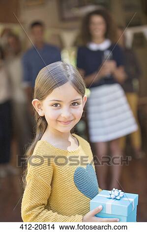Young girl holding gift View Large Photo Image Picture - Young girl holding gift . Fotosearch
