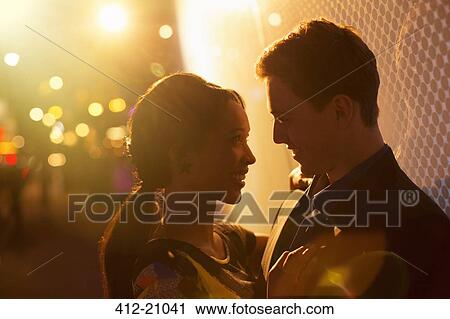 Couple hugging on city street at night View Large Photo Image Stock Image - Couple hugging on city street at night . Fotosearch