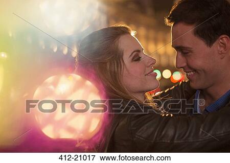 Stock Photo - Couple hugging on city street at night. Fotosearch