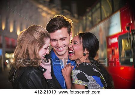 Friends hugging on city street at night View Large Photo Image Stock Photo - Friends hugging on city street at night . Fotosearch
