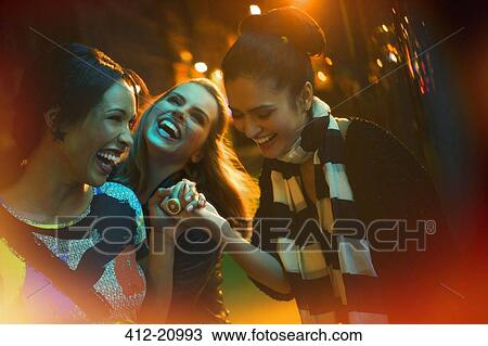 Stock Image - Friends laughing on city street. Fotosearch