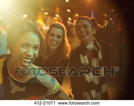 Friends playing on city street at night View Large Photo Image Stock Image - Friends playing on city street at night. Fotosearch