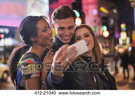 Stock Image - Friends taking picture together with cell phone . Fotosearch