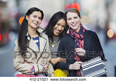Friends walking down city street together View Large Photo Image Stock Image - Friends walking down city street together. Fotosearch