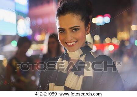 Woman smiling on city street at night View Large Photo Image Stock Photo - Woman smiling on city street at night. Fotosearch