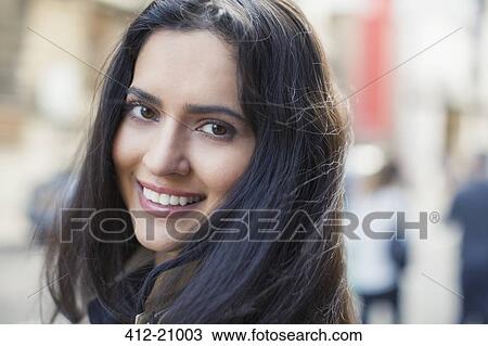Stock Image - Woman smiling on city street. Fotosearch