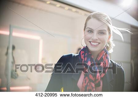 Stock Photography - Woman standing in front of store in city. Fotosearch