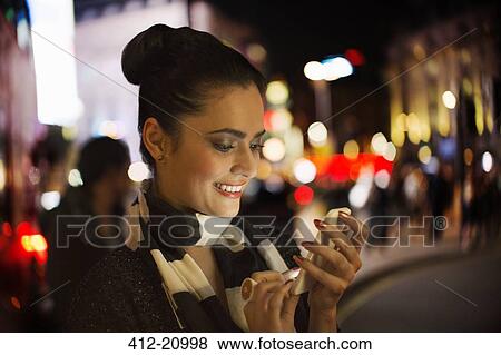 Woman using cell phone on city street View Large Photo Image Stock Photo - Woman using cell phone on city street. Fotosearch
