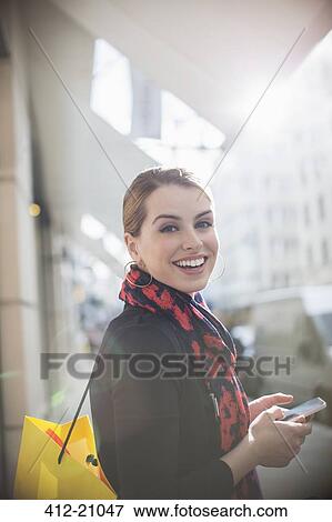 Woman using cell phone on city street View Large Photo Image Stock Photo - Woman using cell phone on city street. Fotosearch