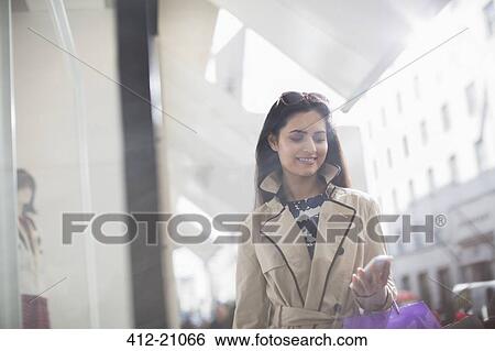 Stock Photograph - Woman using cell phone on city street . Fotosearch