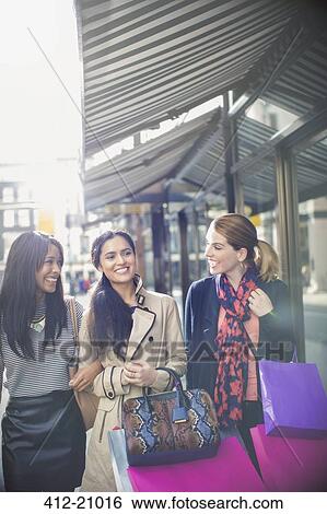 Stock Photograph - Woman walking down city street together. Fotosearch