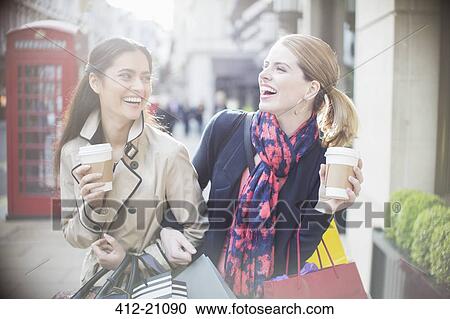 Women drinking coffee together on city street View Large Photo Image Stock Image - Women drinking coffee together on city street. Fotosearch