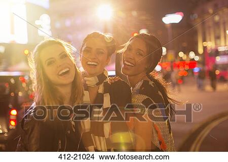 Picture - Women laughing together on city street . Fotosearch